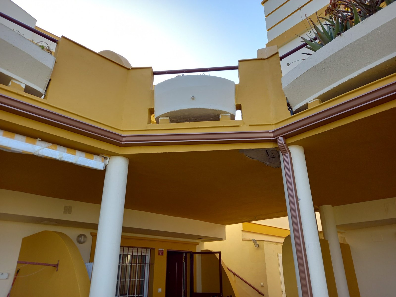 Canalones de aluminio color arena para fachada clara en Cádiz